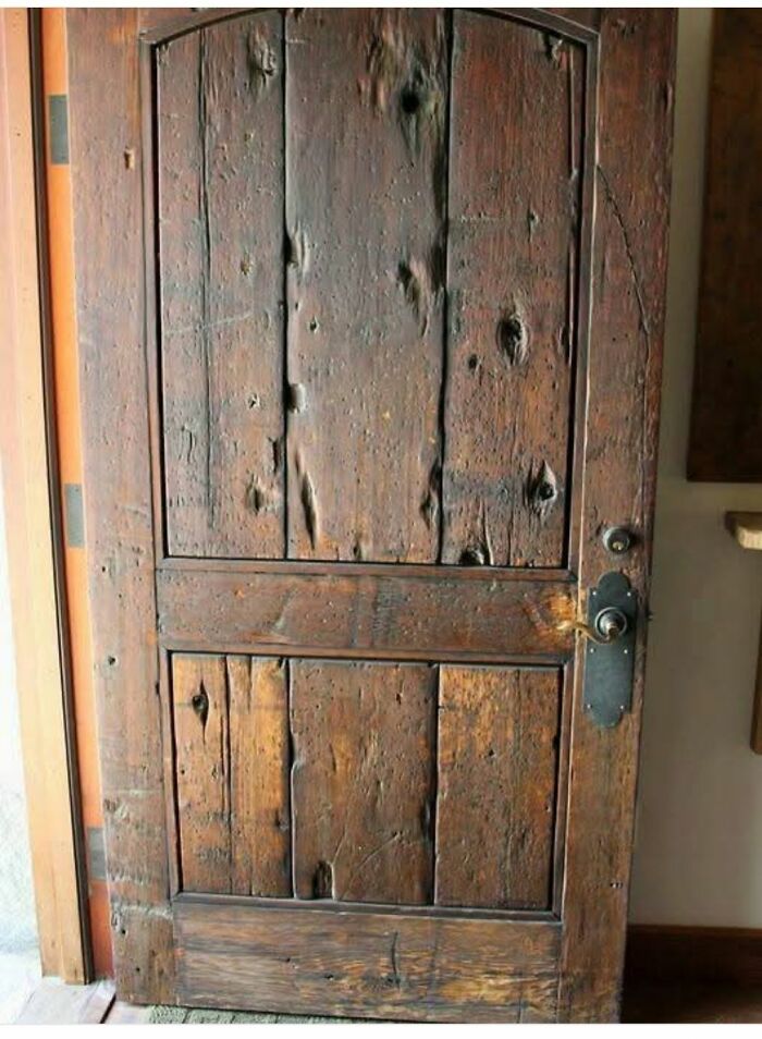 Worn wooden door with old hardware, showing signs of age in a home with a hidden or haunted past. Worn wooden door with old hardware, showing signs of age in a home with a hidden or haunted past.