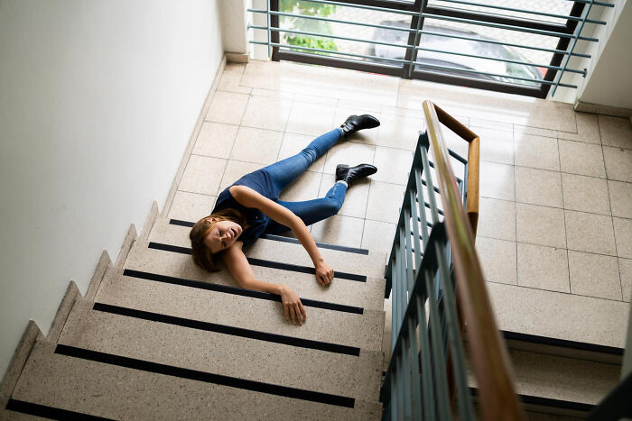 Woman lying on stairs after a fall, illustrating one of the wildest life blunders people keep secret until six feet under.