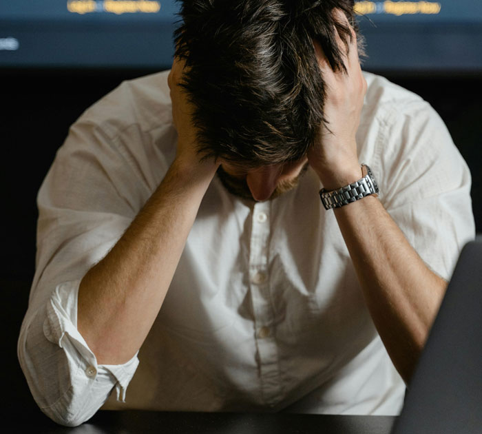 Frustrated man in white shirt holding his head, representing manager told staff not to fill empty shelves and sales issues. Frustrated man in white shirt holding his head, representing manager told staff not to fill empty shelves and sales issues.