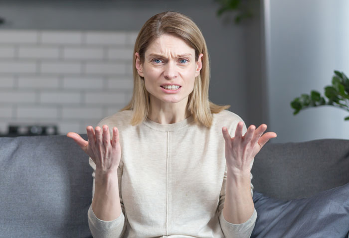 Frustrated woman sitting on couch upset after being left to babysit girlfriend’s kids by roommate not doing parent thing Frustrated woman sitting on couch upset after being left to babysit girlfriend’s kids by roommate not doing parent thing