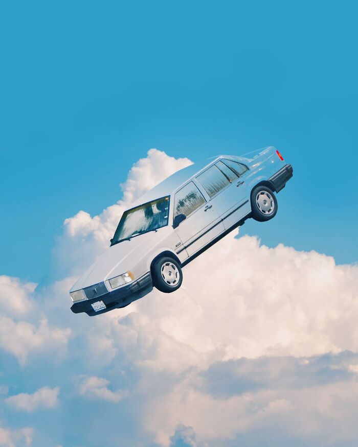 White car floating in a bright blue sky with clouds, showcasing creative photo manipulations and surreal reality elements.