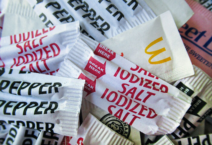 Assorted single-use packets of salt, pepper, and sugar highlighting a tiny thing that made the trip better.