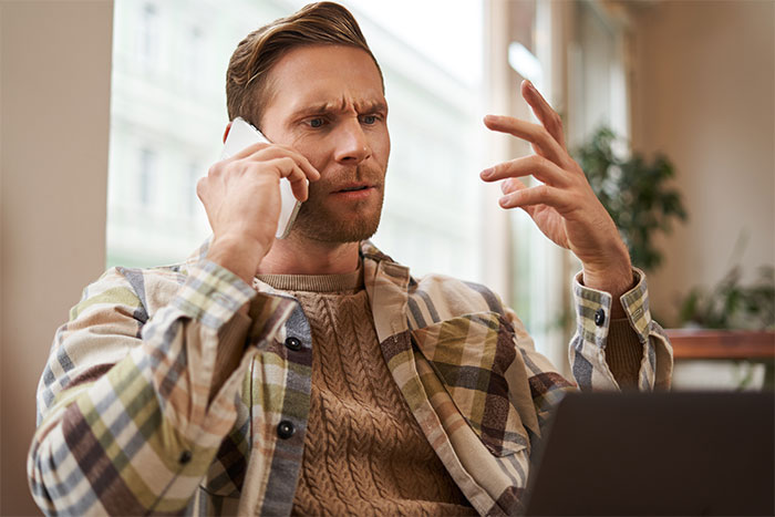 Man looking frustrated while talking on phone, possibly discussing feeding nieces junk food for several days. Man looking frustrated while talking on phone, possibly discussing feeding nieces junk food for several days.
