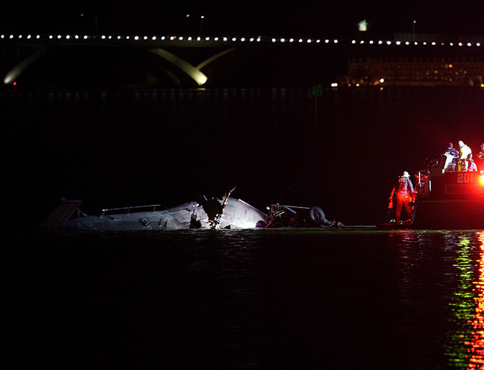 Wreckage of DC plane crash in water at night with rescue team searching the scene and emergency lights reflecting. Wreckage of DC plane crash in water at night with rescue team searching the scene and emergency lights reflecting.