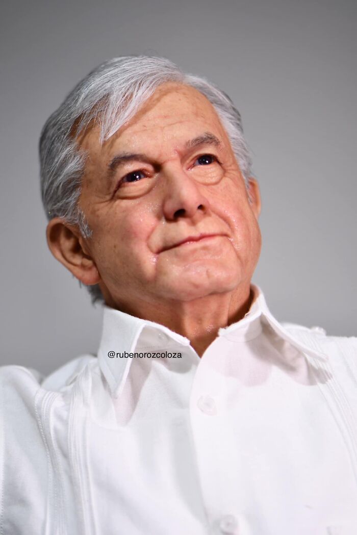 Hyper-realistic sculpture by Ruben Orozco Loza of an elderly man with white hair wearing a white shirt.