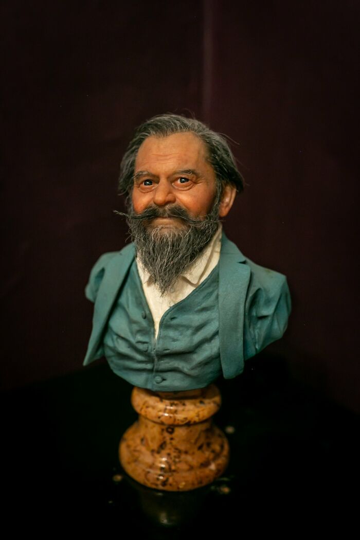 Highly realistic sculpture bust by Ruben Orozco Loza showing an elderly man with detailed facial features and clothing.