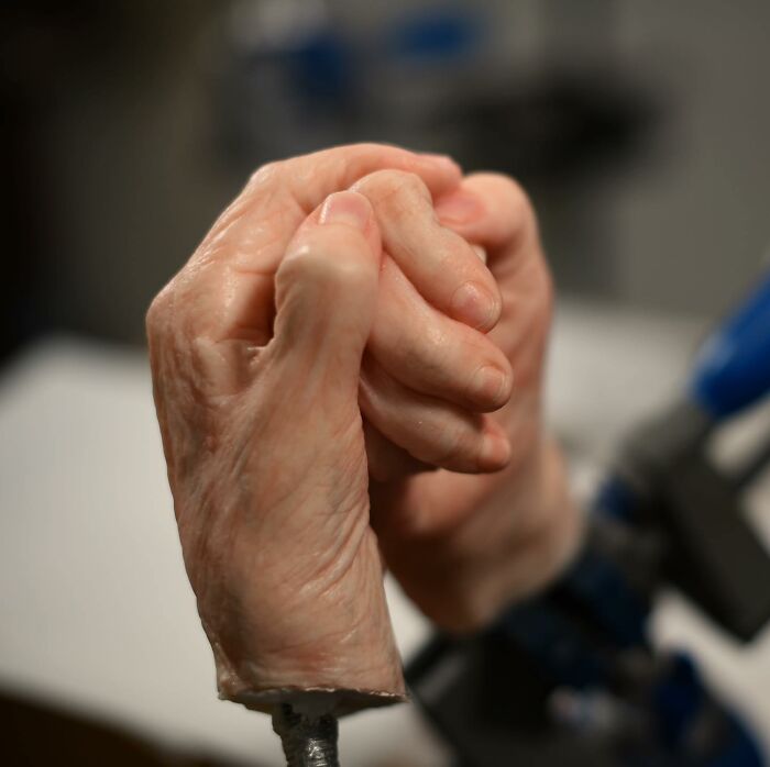 Hyper-realistic sculpture of intertwined hands by Ruben Orozco Loza showcasing breathtaking realism in fine detail.