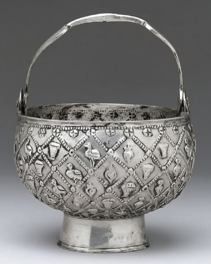 Ancient silver bucket with intricate engraved patterns and animal motifs, showcasing archaeology news and architecture details.