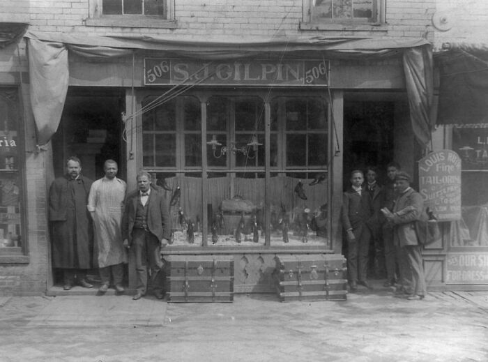African American men standing outside a small store in early 1900s, capturing African American life history.