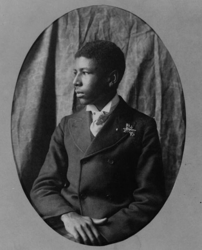 African American man in formal 1900 Paris Exposition attire posing for a portrait, capturing African American life.
