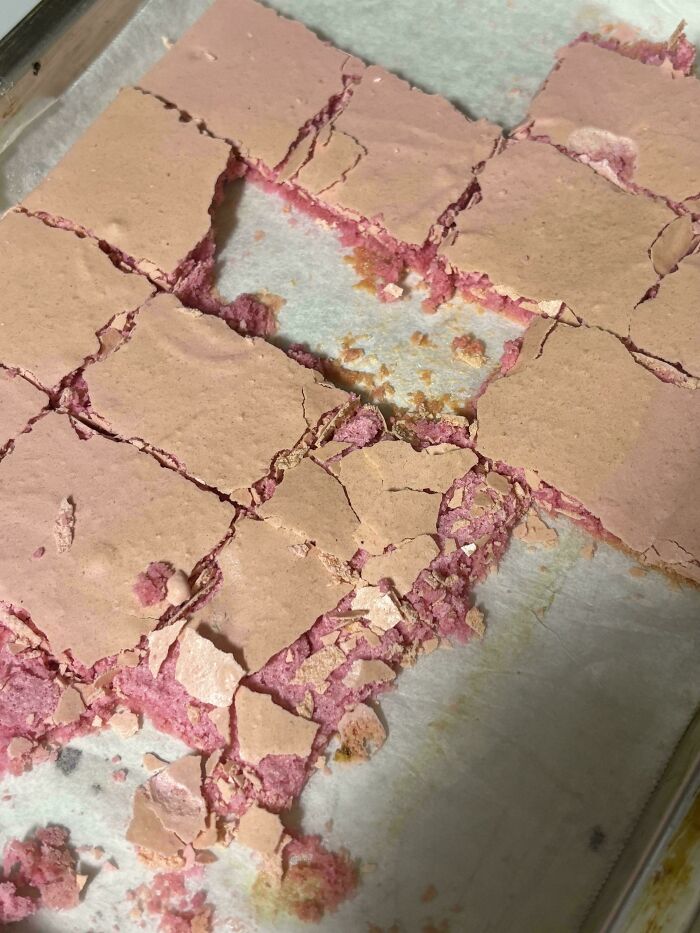 Baking fail with c*****d and broken pink dessert on parchment paper, showcasing a cooking fail mishap.