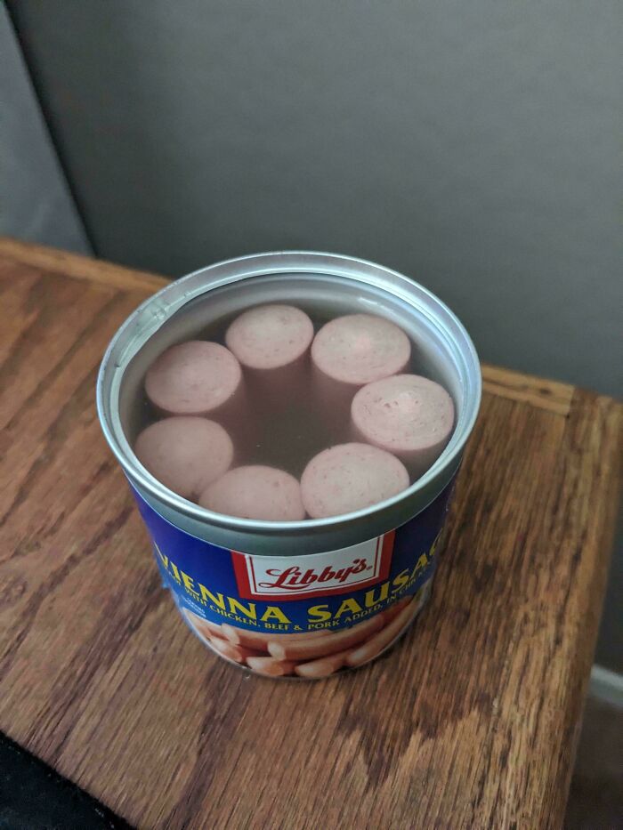 Opened can of Vienna sausage showing small sausages in liquid, illustrating products getting smaller and more expensive.