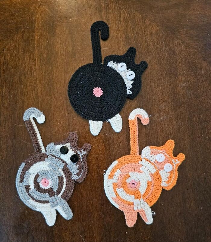 Crocheted cat coasters with button eyes on wooden surface, funny finds under 10 dollars for laughter and budget fun.