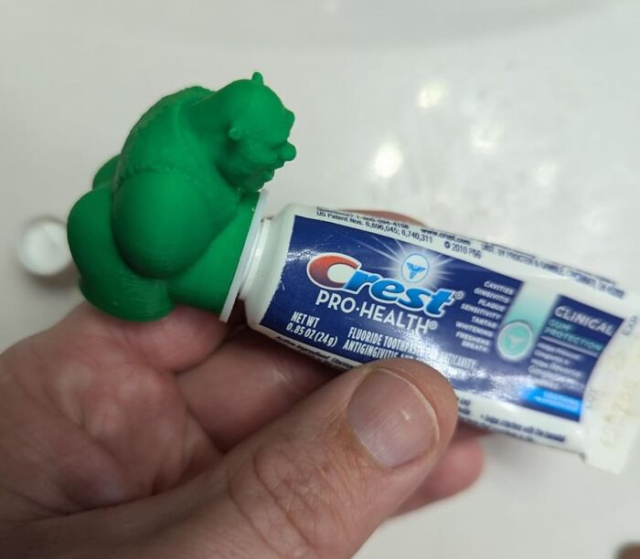 Green Hulk toothpaste cap on a Crest tube held in hand showing a funny and affordable find under $10.