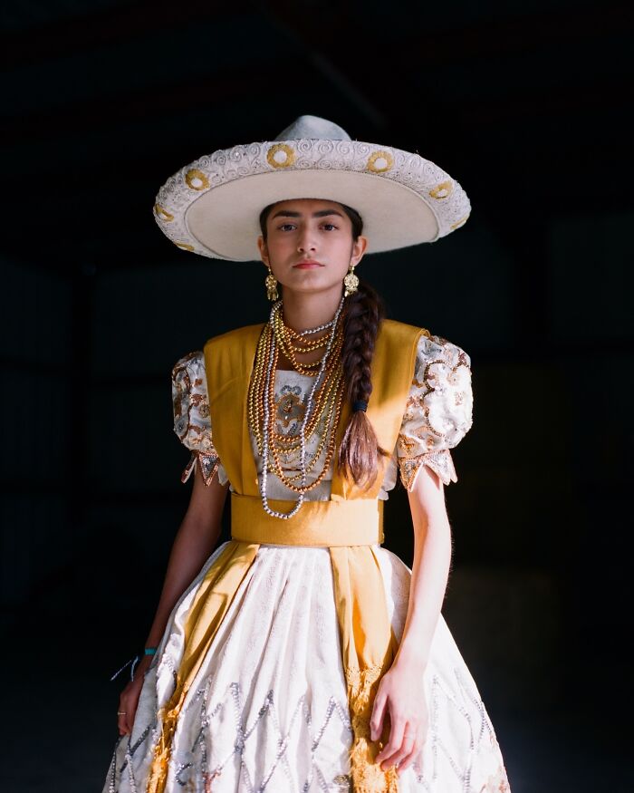 Young all-female rodeo rider wearing traditional attire and a wide-brimmed hat, showcasing strength and beauty.