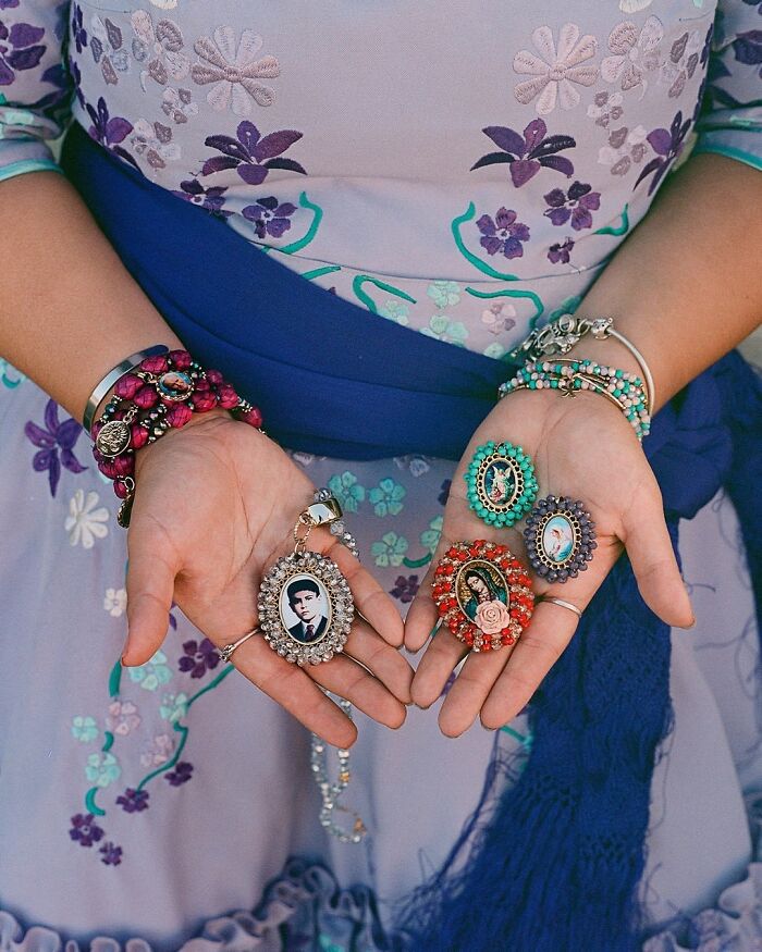 Hands of an all-female rodeo rider holding vintage photo lockets, showcasing beauty and power in rodeo culture.