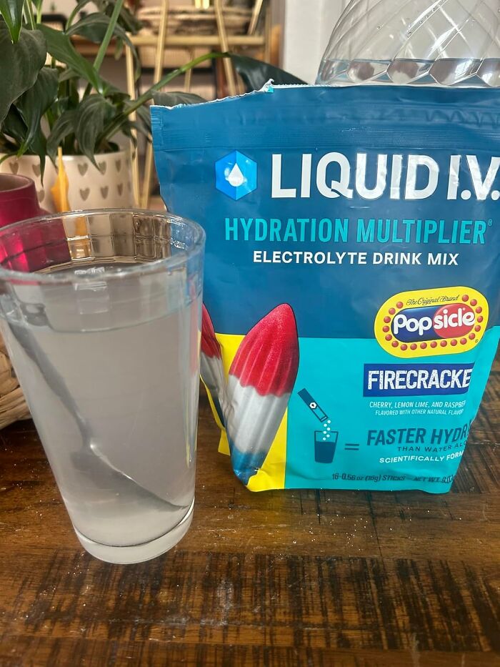 Electrolyte drink mix with glass of water, promoting hydration multiplier for warm weather finds and better seasonal hydration.