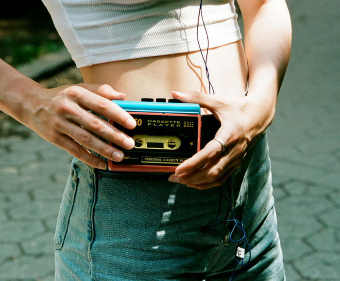 Person holding retro cassette player at waist outdoors, illustrating moments of strangers unsuccessfully attempting to mug them.
