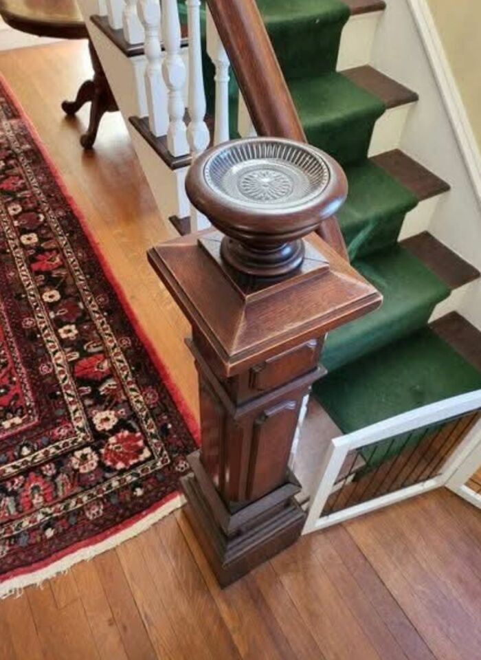 Ornate wooden newel post bowl feature on staircase in home with hidden and haunted past. Ornate wooden newel post bowl feature on staircase in home with hidden and haunted past.