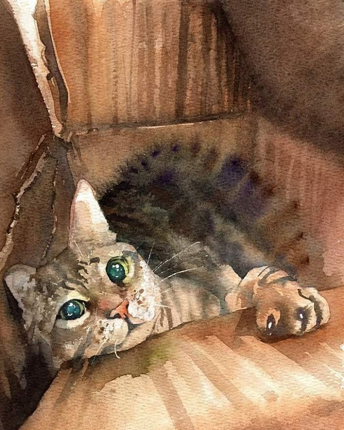 Watercolor painting of a tabby cat with green eyes resting on wooden furniture in cat art style.