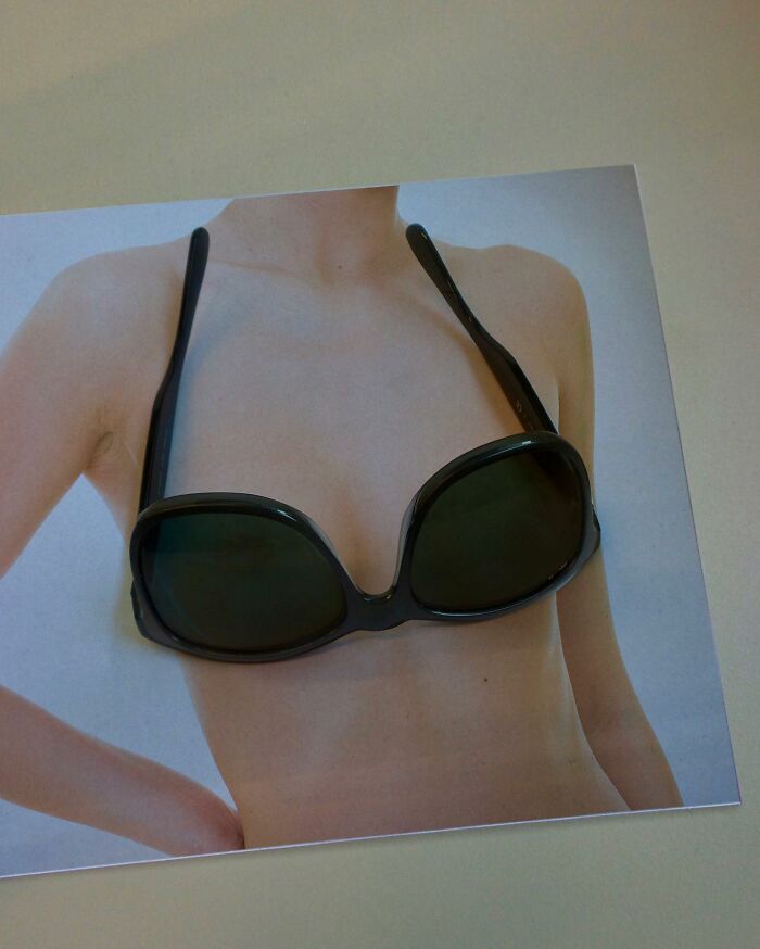 Photo manipulation showing sunglasses positioned on a printed image of a woman's torso creating an optical illusion.