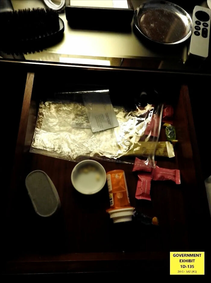 Open drawer with various items including pills, wrappers, and a brush, part of Diddy trial disturbing items evidence. Open drawer with various items including pills, wrappers, and a brush, part of Diddy trial disturbing items evidence.