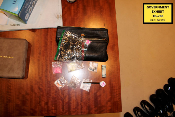 Evidence bags with various items including rolled cash on a wooden table labeled as government exhibit in Diddy trial. Evidence bags with various items including rolled cash on a wooden table labeled as government exhibit in Diddy trial.