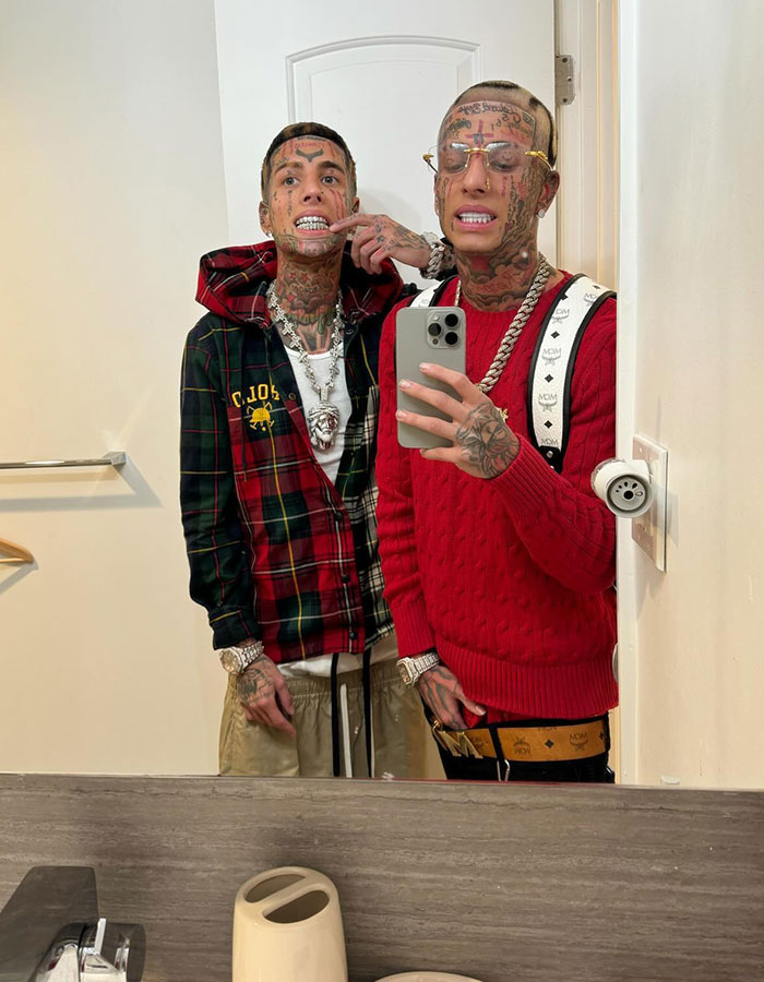 Two tattooed men taking a mirror selfie, showcasing bold style and accessories, highlighting Island Boy and ET's Baby presence. Two tattooed men taking a mirror selfie, showcasing bold style and accessories, highlighting Island Boy and ET's Baby presence.