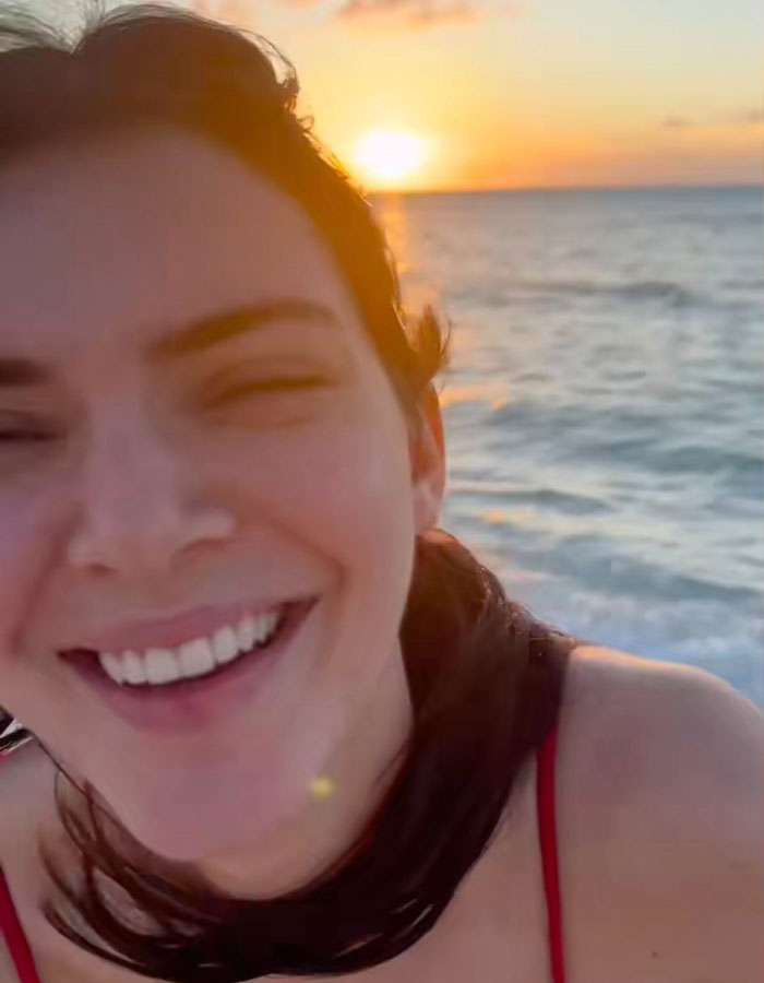 Smiling woman enjoying a sunset beach walk with ocean waves in the background, showcasing talent and carefree vibes. Smiling woman enjoying a sunset beach walk with ocean waves in the background, showcasing talent and carefree vibes.