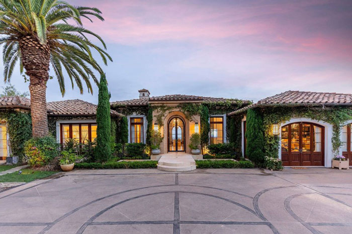 Luxury Montecito home with Mediterranean design, lush greenery, and a vibrant sunset sky in a controlled image setting. Luxury Montecito home with Mediterranean design, lush greenery, and a vibrant sunset sky in a controlled image setting.