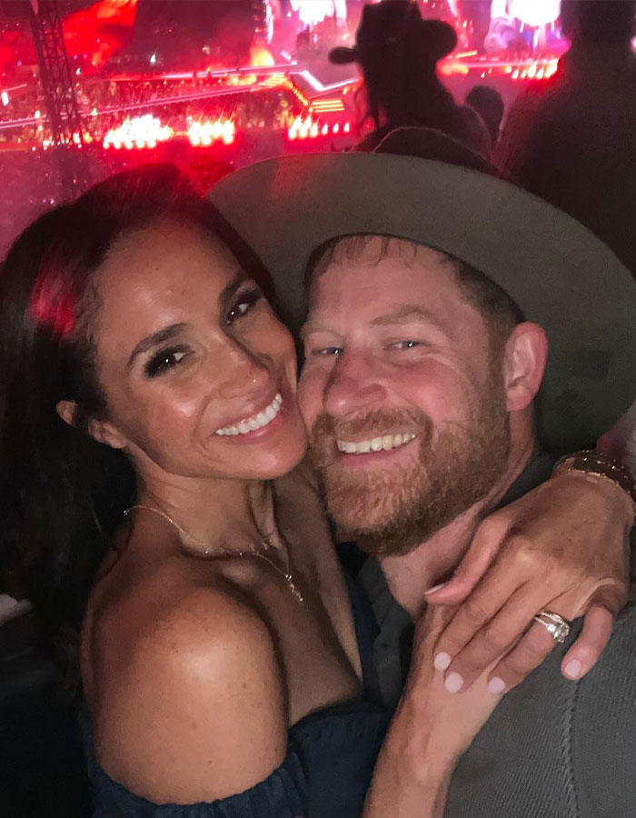 Meghan Markle and Prince Harry smiling and hugging at an event, sharing a moment related to Mother’s Day snap of Lilibet and Archie. Meghan Markle and Prince Harry smiling and hugging at an event, sharing a moment related to Mother’s Day snap of Lilibet and Archie.