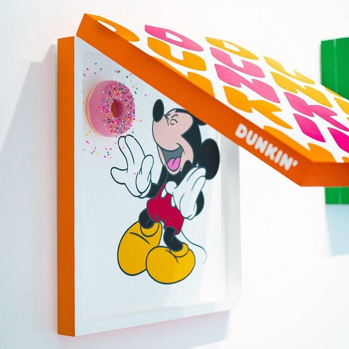 Mickey Mouse artwork covered in colorful sprinkles with a pink sprinkle-covered donut in vibrant art installation.