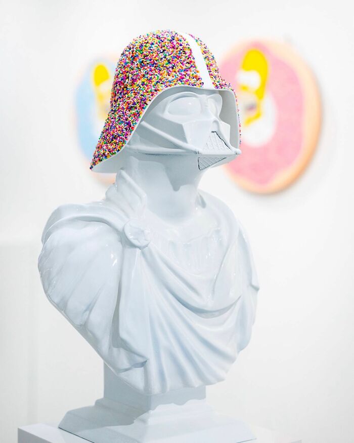 White bust sculpture wearing a helmet covered in colorful sprinkles, showcasing unique sprinkle art by Pepe Bratanov.