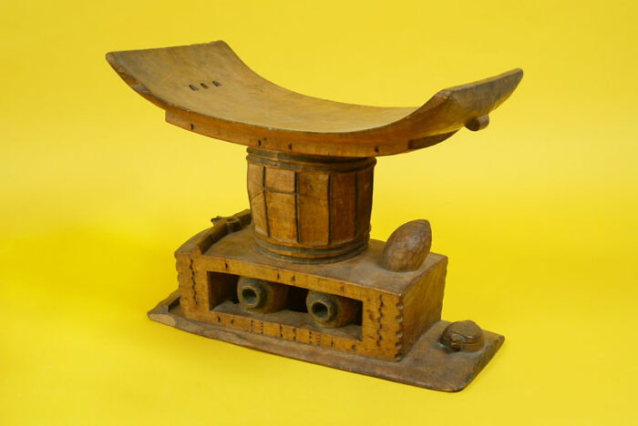 Wooden artifact with a curved top and intricate base, representing bizarre historical events and unique cultural objects.