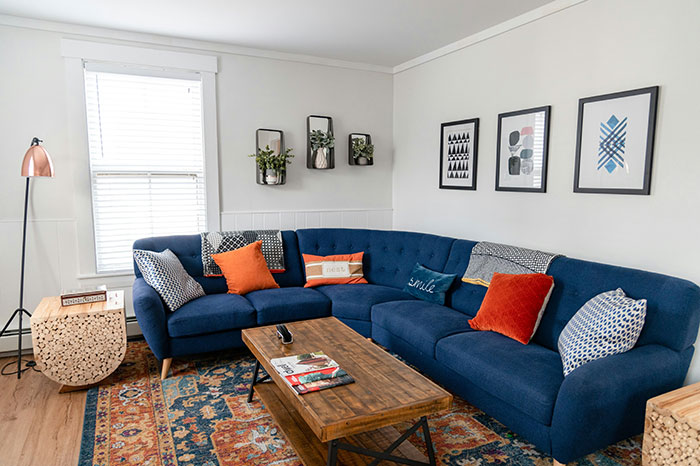 Cozy living room with blue sectional sofa and colorful pillows, perfect for Airbnb stays and guest comfort. Cozy living room with blue sectional sofa and colorful pillows, perfect for Airbnb stays and guest comfort.