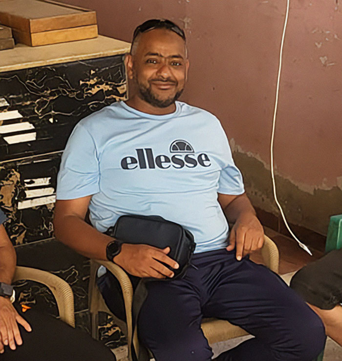 Man sitting indoors wearing a light blue ellesse shirt, representing father of four with only 37 followers jailed over deleted tweet. Man sitting indoors wearing a light blue ellesse shirt, representing father of four with only 37 followers jailed over deleted tweet.