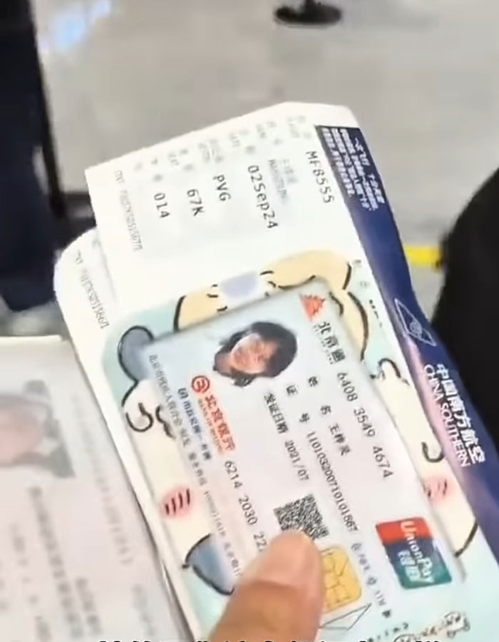 Passenger holding ID card and boarding pass at airport after facial recognition failed due to makeup removal request. Passenger holding ID card and boarding pass at airport after facial recognition failed due to makeup removal request.