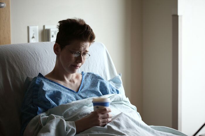 Person in a hospital gown holding a cup, reflecting on morally questionable acts like swearing and piracy by netizens.