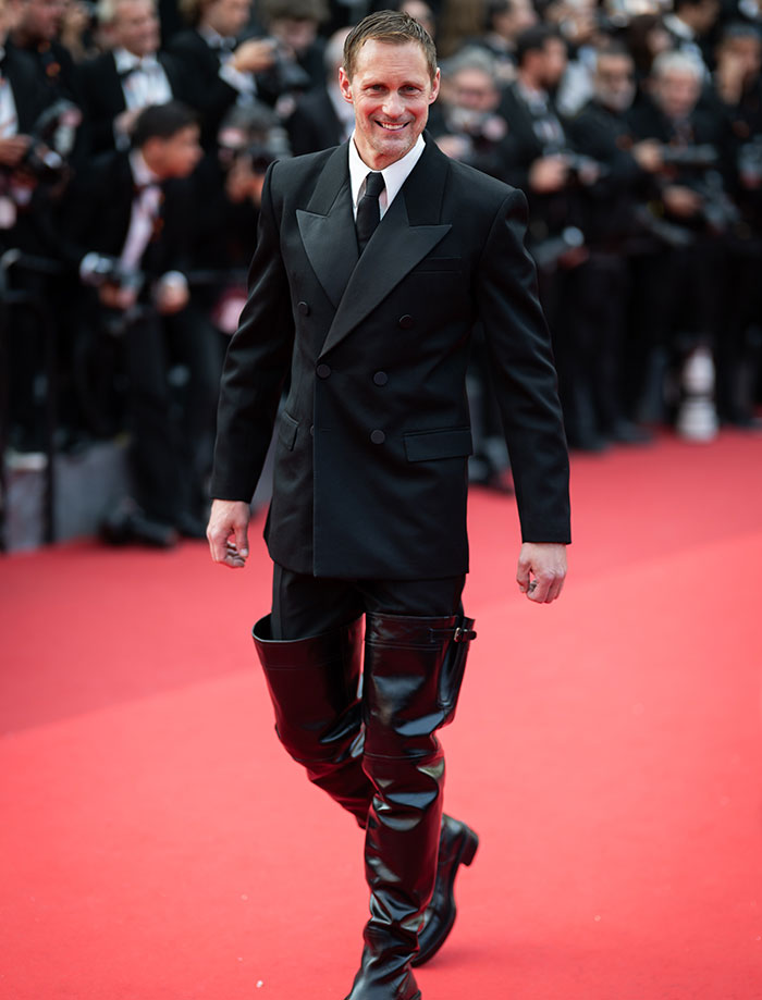 Actor on red carpet wearing black suit and leather thigh-high boots at event linked to Harry Potter star in X-rated gay film. Actor on red carpet wearing black suit and leather thigh-high boots at event linked to Harry Potter star in X-rated gay film.
