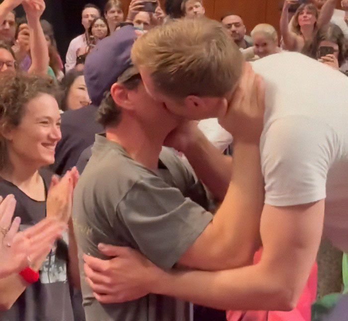 Two men kissing passionately as a crowd applauds, highlighting a Harry Potter star in an X-rated gay film scene. Two men kissing passionately as a crowd applauds, highlighting a Harry Potter star in an X-rated gay film scene.