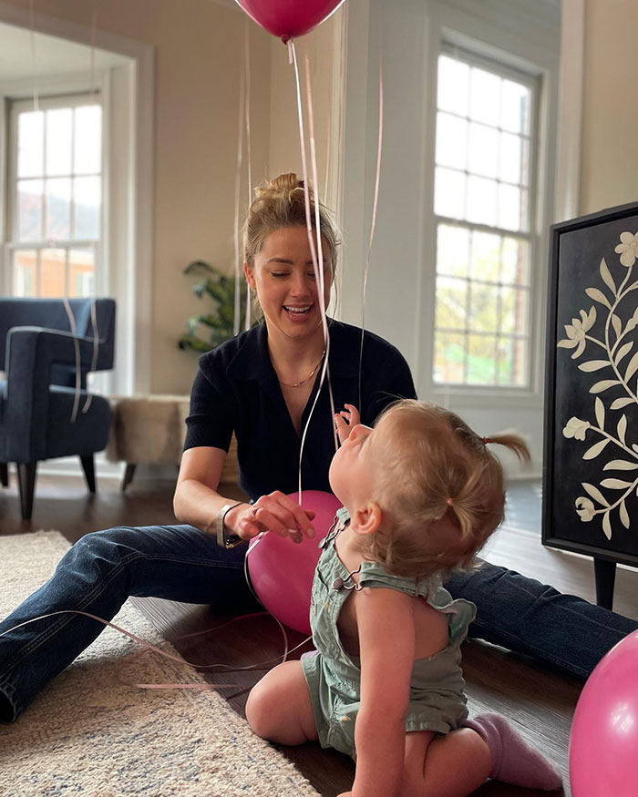Amber Heard playing with her toddler indoors surrounded by pink balloons, related to Elon Musk twins speculation. Amber Heard playing with her toddler indoors surrounded by pink balloons, related to Elon Musk twins speculation.