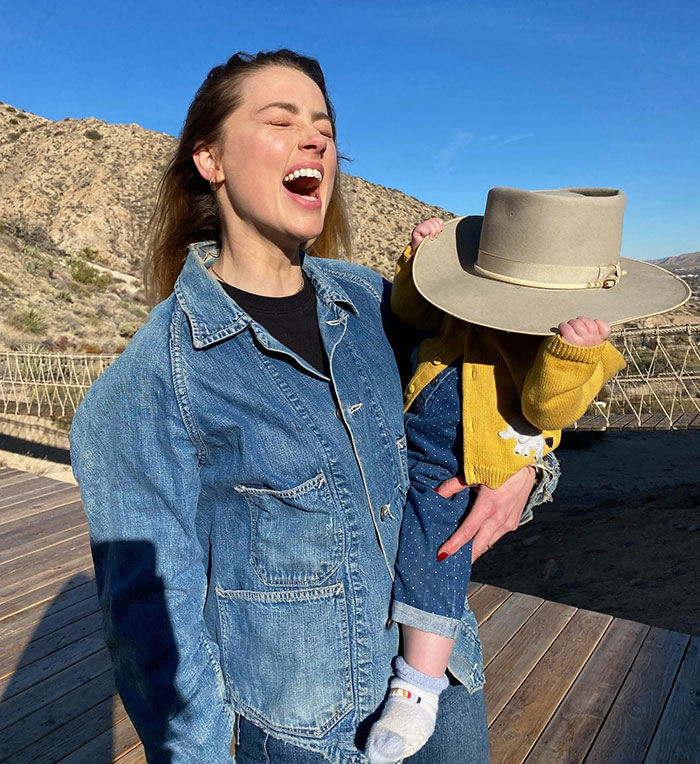 Amber Heard holding her child outdoors with a hat, linked to Elon Musk and twins embryos dispute rumors. Amber Heard holding her child outdoors with a hat, linked to Elon Musk and twins embryos dispute rumors.
