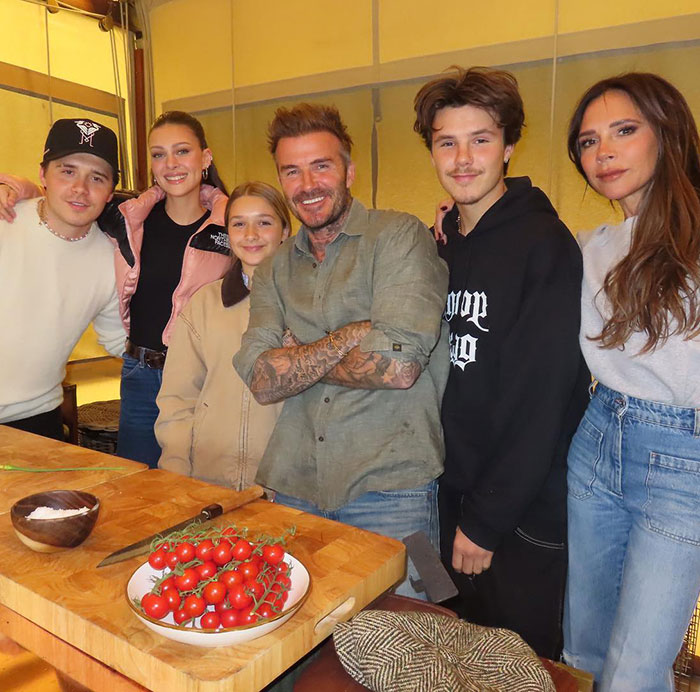 Victoria Beckham with family in a casual kitchen setting amid wedding rumors involving Nicola Peltz and her son's event. Victoria Beckham with family in a casual kitchen setting amid wedding rumors involving Nicola Peltz and her son's event.