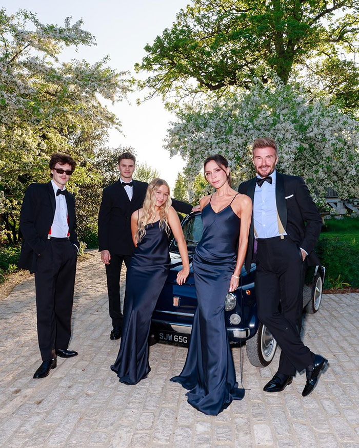 Victoria Beckham and family dressed elegantly outdoors near vintage car during wedding, linked to deeply hurtful wedding incident. Victoria Beckham and family dressed elegantly outdoors near vintage car during wedding, linked to deeply hurtful wedding incident.