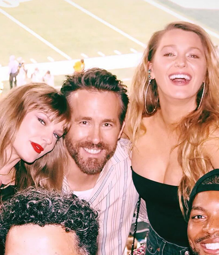 Taylor Swift and Blake Lively smiling with friends at an outdoor event, capturing a joyful moment together. Taylor Swift and Blake Lively smiling with friends at an outdoor event, capturing a joyful moment together.