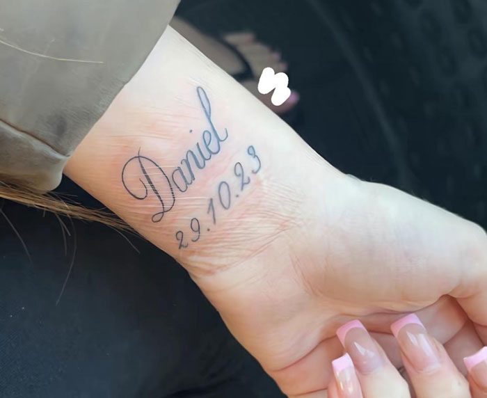 Close-up of a woman's wrist tattoo honoring her late boyfriend, highlighting a name and a date in delicate script. Close-up of a woman's wrist tattoo honoring her late boyfriend, highlighting a name and a date in delicate script.