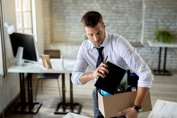 Worker in office packing belongings into a box, showing the moment of being fired and new project refusal. Worker in office packing belongings into a box, showing the moment of being fired and new project refusal.