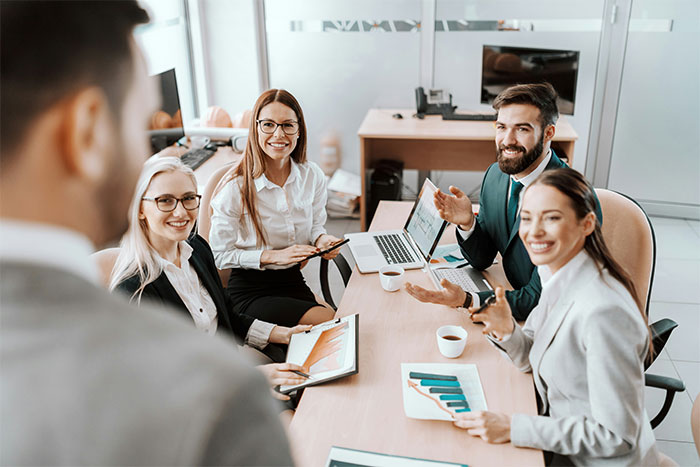 Group of workers in a meeting discussing a new project assignment despite recent firing news in a modern office. Group of workers in a meeting discussing a new project assignment despite recent firing news in a modern office.