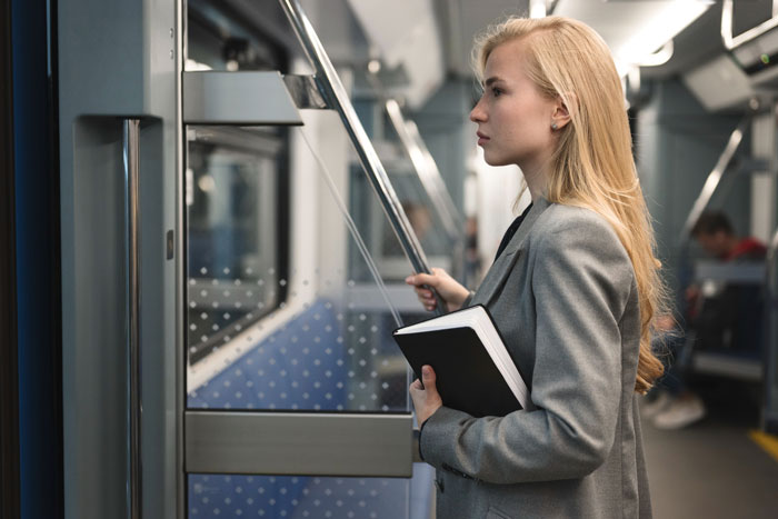 Young professional woman holding a notebook, standing in a subway, illustrating boss obsessed with punctuality and clever worker. Young professional woman holding a notebook, standing in a subway, illustrating boss obsessed with punctuality and clever worker.