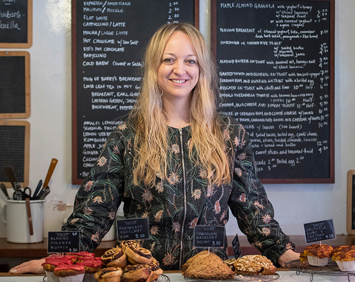 Woman standing behind a counter with baked goods, representing Meghan Markle allegedly berating her wedding caterer. Woman standing behind a counter with baked goods, representing Meghan Markle allegedly berating her wedding caterer.